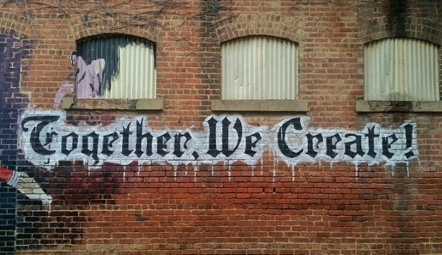 Graffiti on a wall "Together we create !"